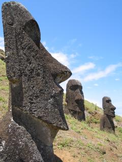 Moai face in profile at left edge, two more in background