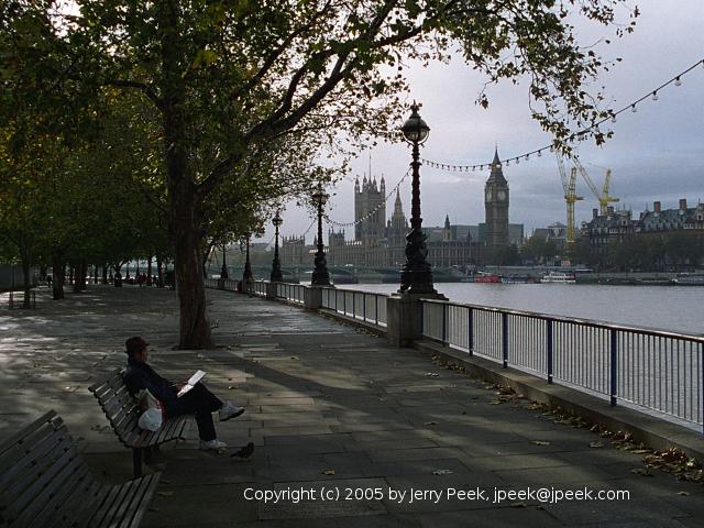 Man reading on bench along South Bank of Thames River