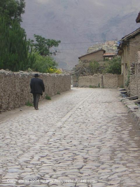 Man walking along a street, Ollantaytambo, Peru
