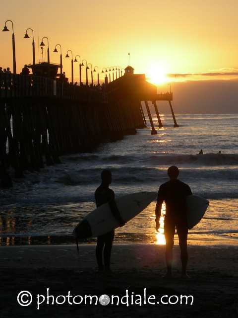 Surfers at sunset near pier - Imperial Beach, California