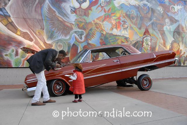 Red low-rider Chevy and David Tineo mural, Tucson Museum of Art plaza